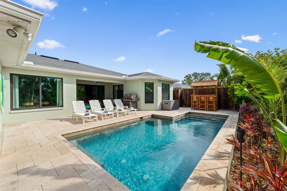 Private Pool Area. Enjoy a sparking pool, sun loungers, and lush tropical landscaping in this relaxing outdoor oasis.