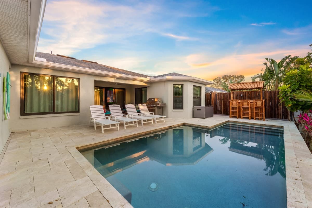 A stunning private pool area. Featuring a sparkling pool, comfortable sun loungers, and lush tropical landscaping, this outdoor oasis is a feast for the senses.